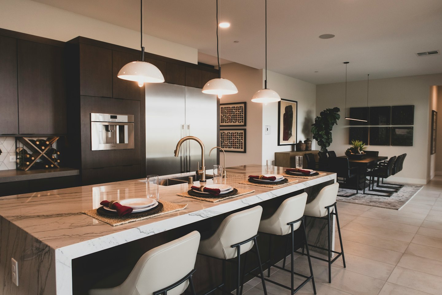 Isla de cocina moderna con taburetes y zona de comedor.