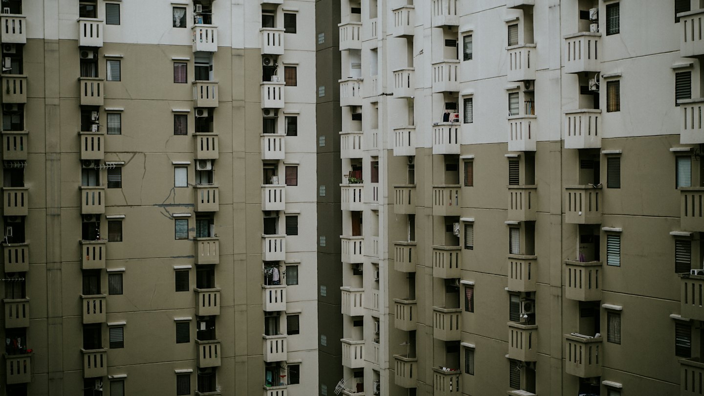 Fachada de edificio de apartamentos con balcones y diversos elementos residenciales.