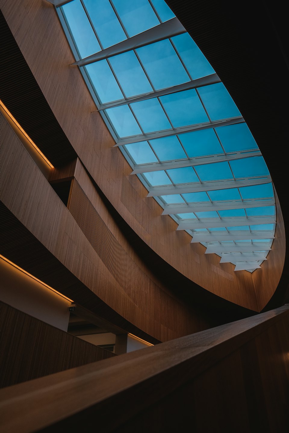 Paredes y techo interiores de madera curvos con texturas lineales.
