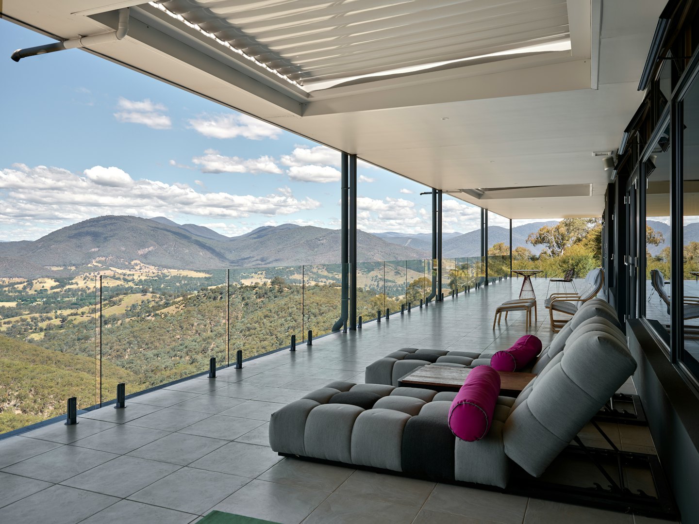 Terraza moderna al aire libre con muebles de salón modulares con vistas al paisaje montañoso.