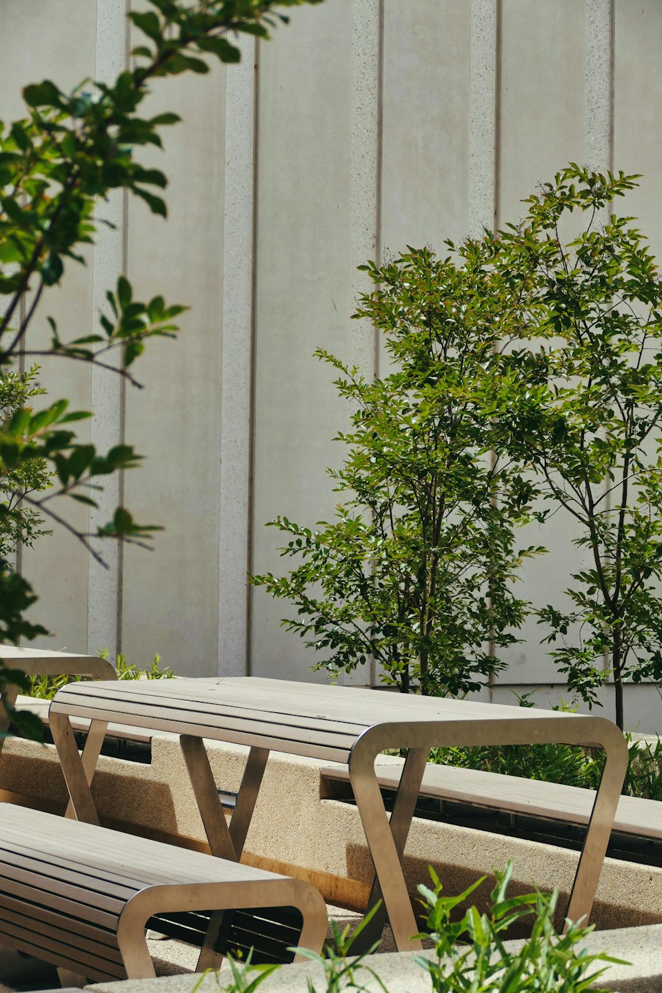 Moderno mobiliario de exterior con bancos y mesas de madera con lamas.